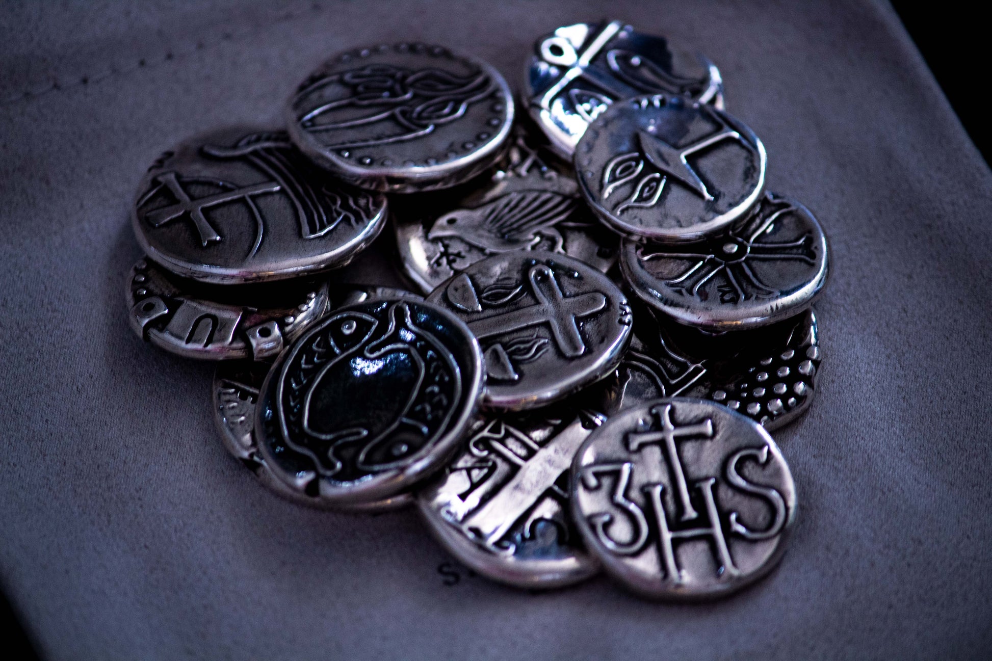 Monedas para Arras con diversas figuras religiosas talladas en cada una de ellas y amontonadas