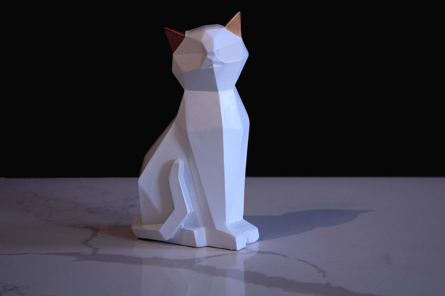 Figura de ornato en forma de gato blanco sentado con orejas doradas vista de frente 