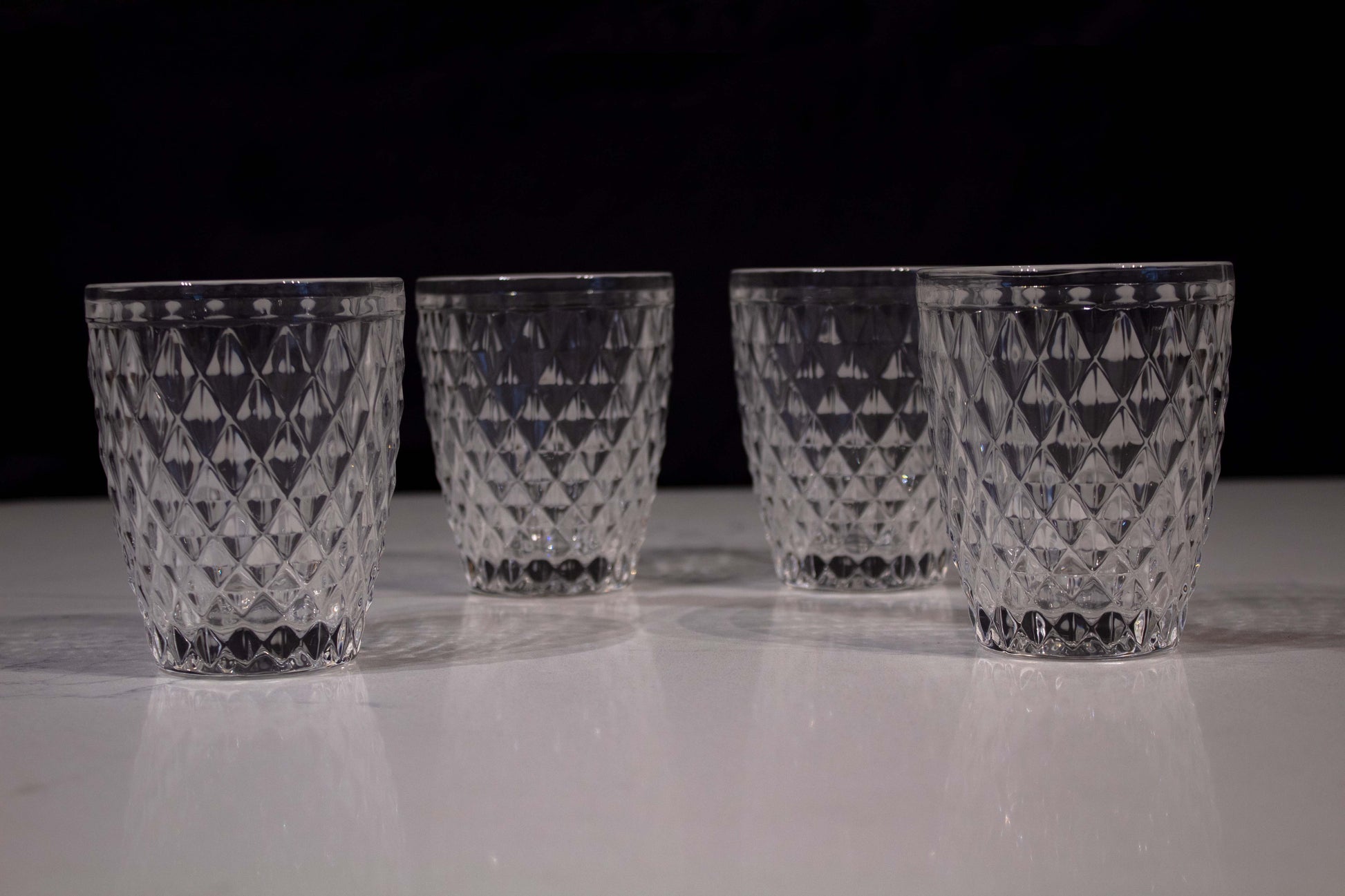 Cuatro vasos de cristal transparente con diseño en forma de diamante